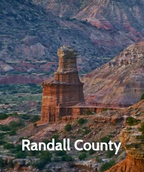 Scenic view of Randall County’s unique geological formation, showcasing the distinctive rock spire amidst rugged terrain and colorful hills.