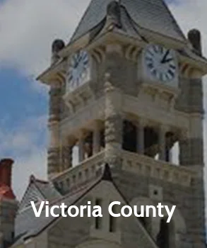 Victoria County courthouse clock tower with intricate stonework and large clock faces, representing Victoria County’s historic and governmental significance.