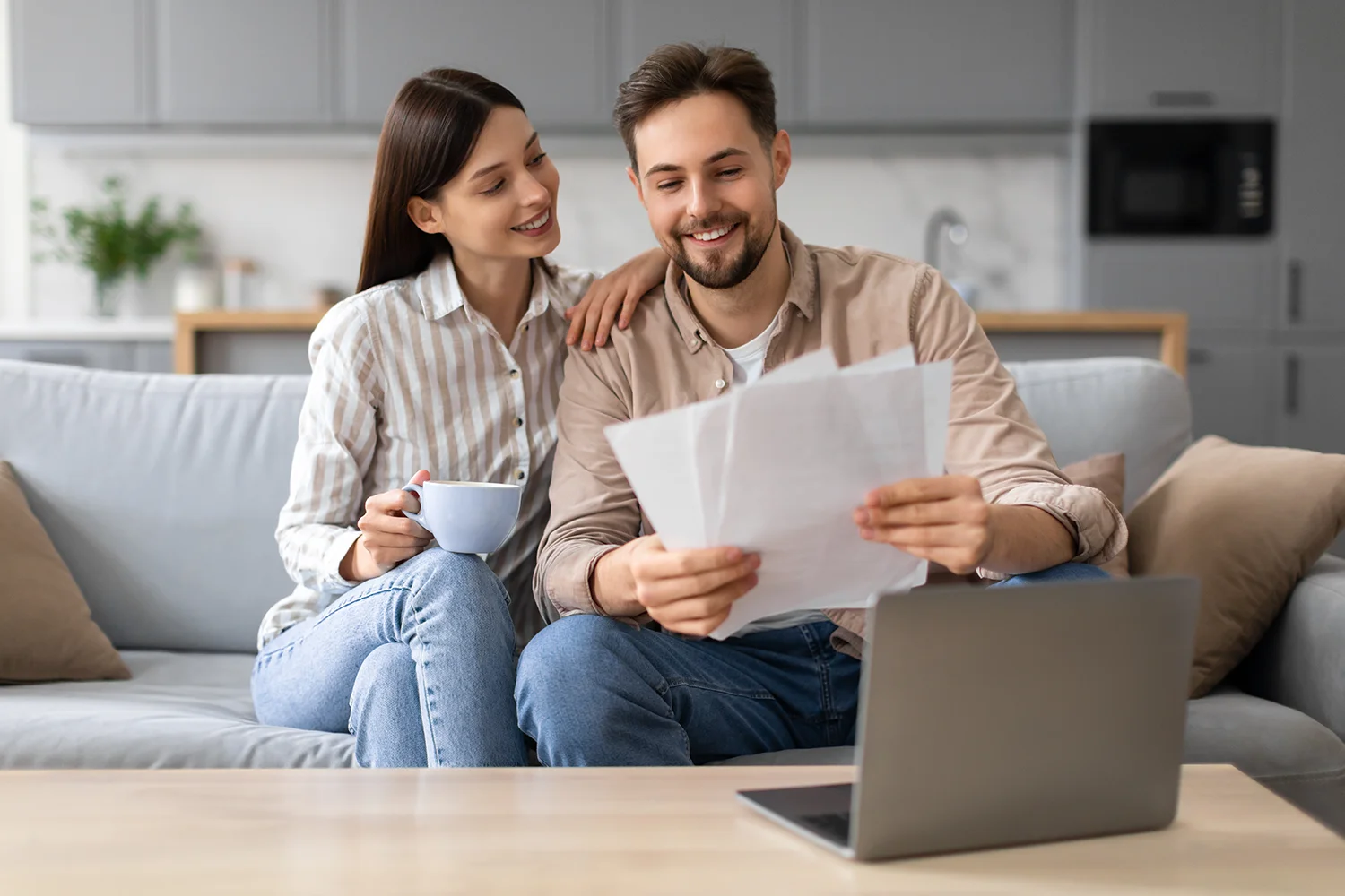 Couple reviewing property tax documents at home while using a laptop, representing homeowners preparing for a property tax protest with professional guidance in Texas.