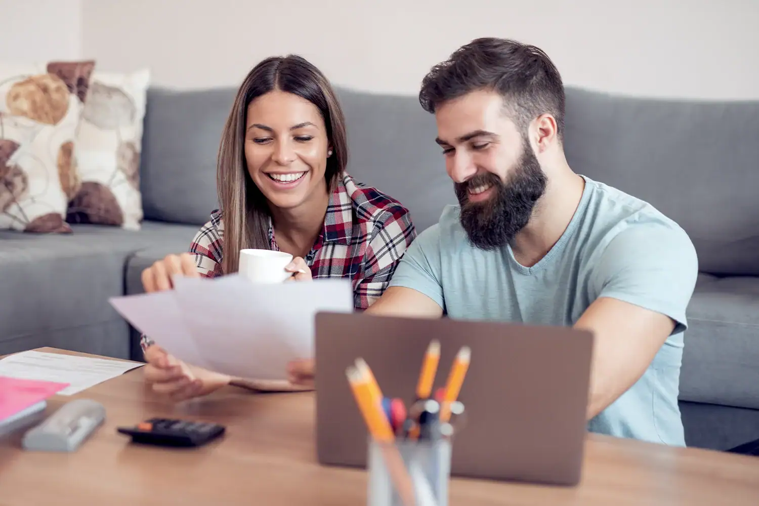 Couple reviewing property tax documents with a laptop at home, representing Houston property tax protest and savings services by Tax Cutter.
